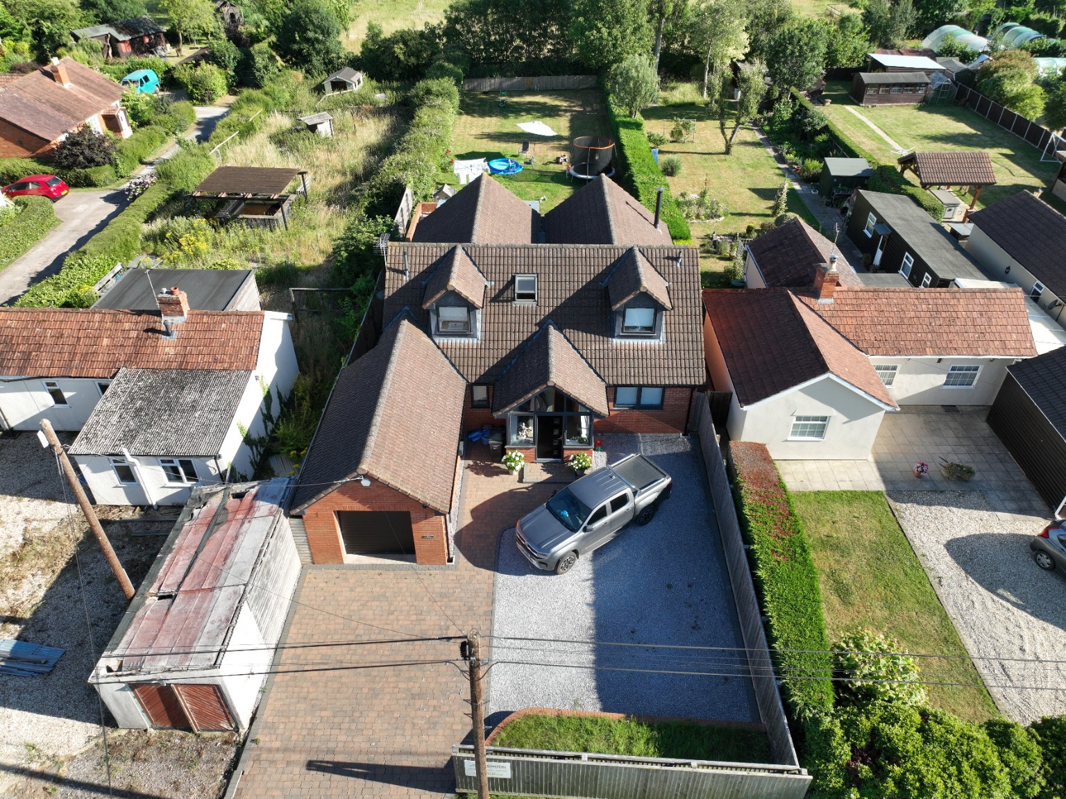 Aerial photograph of a detached house with driveway and long rear garden