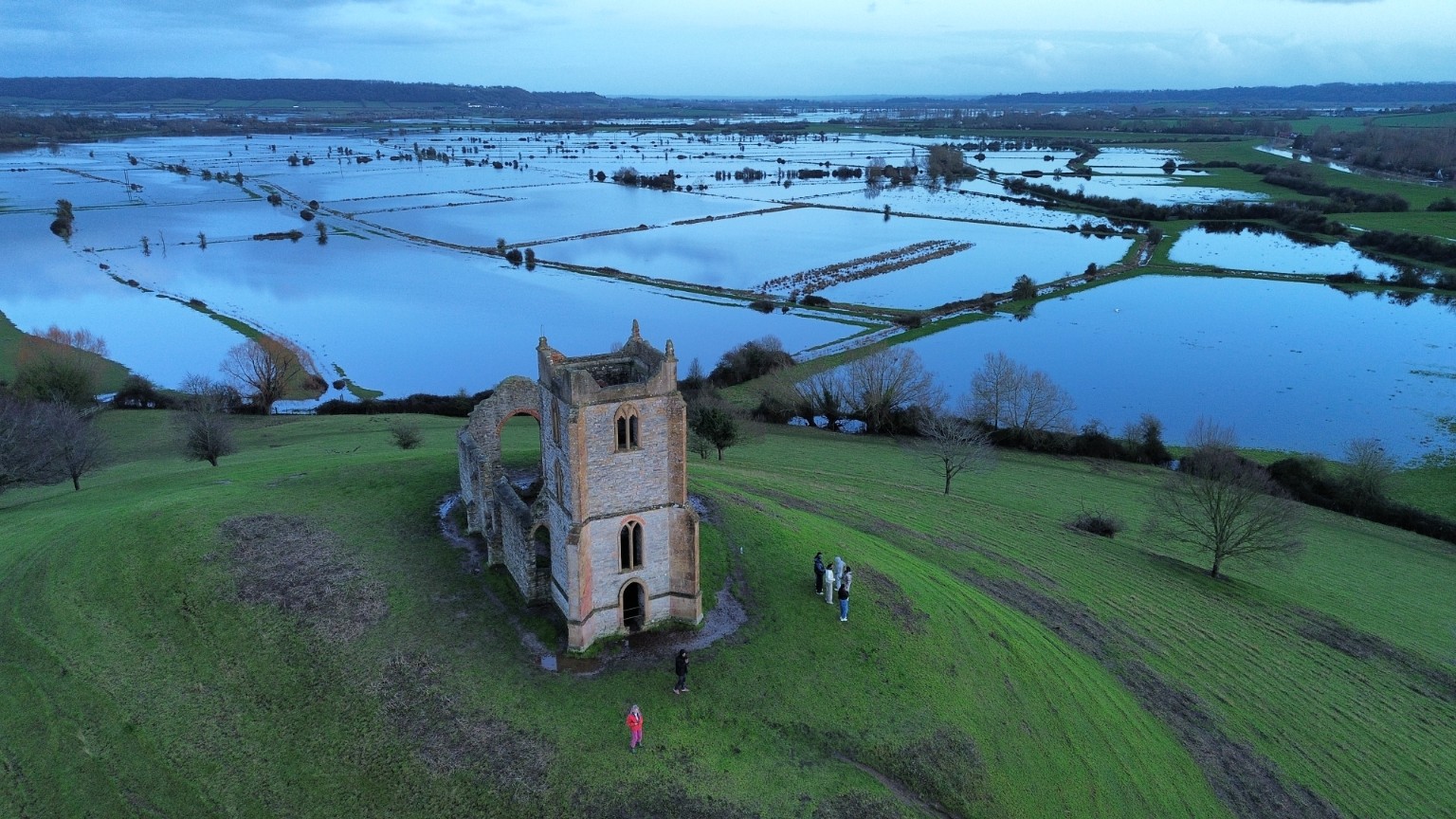 Aerial view of historic church ruins beside flooded countryside