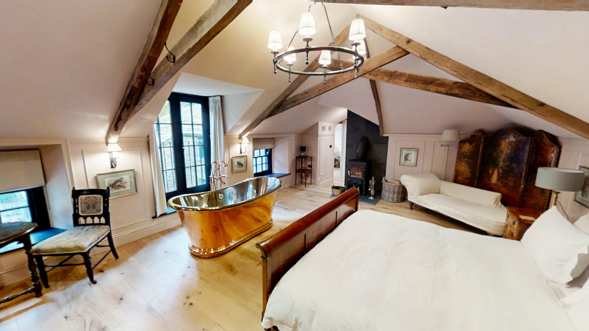 Bedroom with exposed beams and a freestanding bath at Boconnion Stables